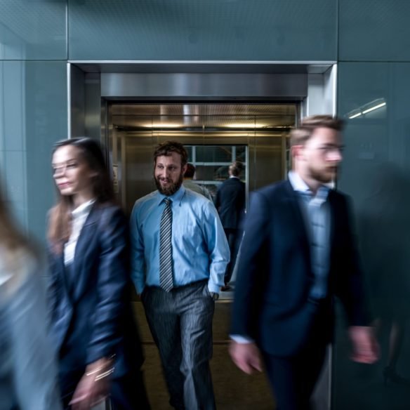 Business people walk out of the lift in the lobby. All rush in conference room on the meeting.
